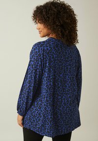 Blå leopardmönstrad blus med långa ärmar, har en avslappnad passform och insamling vid ärmsluten. Slät tygtextur med en flödande design.