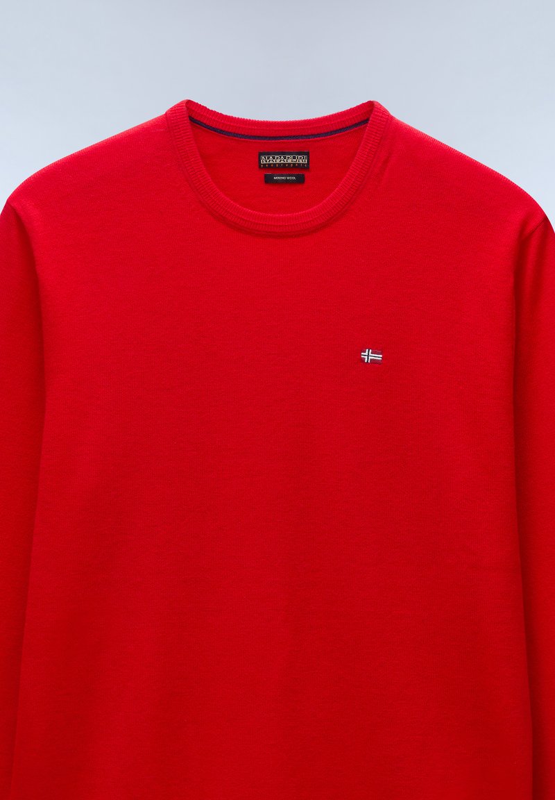 Czerwony sweter z wełny merino z okrągłym dekoltem, z małym emblematem norweskiej flagi na lewej piersi oraz metką marki Napapijri wewnątrz kołnierza.