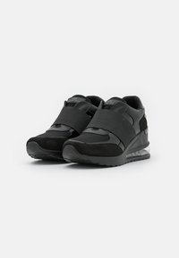 Czarne sneakersy wykonane z połączenia gładkiej skóry i zamszu, z grubym paskiem na śródstopiu oraz przezroczystymi akcentami na podeszwie.