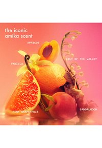 Arrangement coloré de fruits et de fleurs comprenant des abricots, du pamplemousse et du muguet sur un fond dégradé rose. Étiquettes de texte présentes.