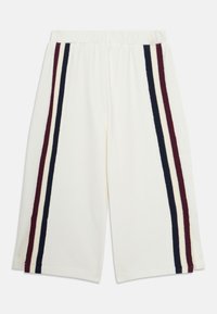 Weiße knielange Shorts mit elastischem Bund, die an jeder Seite dunkelrot, marineblau und weiße vertikale Streifen aufweisen.