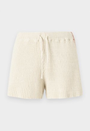 Cremfarbene Strickshorts mit gerippter Textur, elastischem Taillenbund und Kordelzug. Mit einem kleinen Akzentetikett an der Seite.
