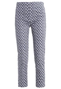 Mörkblå mönstrade leggings med ett upprepat hjärtdesign i vitt, tillverkade av ett elastiskt tyg med en åtsittande silhuett.