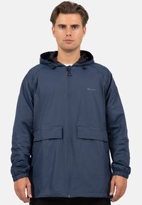 Marineblauwe waterdichte jas met een capuchon, voorrits, twee grote zakken, elastische manchetten en een gladde textuur. Merklogo op de borst.