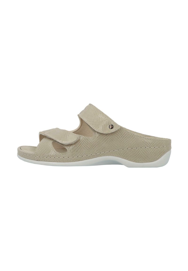 Beige slip-on sandal with textured upper, two adjustable straps, open toe design, and a cushioned sole with a white accent.