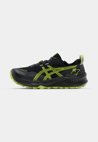 Black running shoe with textured mesh upper, lime green accents, and rugged sole. Features pronounced tread and logo details on side.