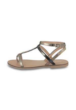 Sandali piatti strappy in metallo oro e nero con design testurizzato, dotati di una cinghia alla caviglia con fibbia e di una suola liscia beige.