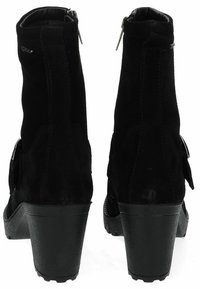 Botas ankle de ante negro con un tacón de goma texturizada negra, cierre de cremallera y acentos decorativos laterales. Presenta un diseño de punta redonda.
