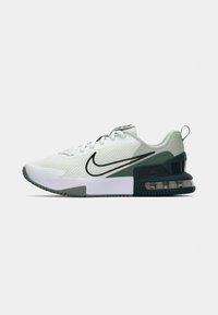Nike športová obuv s sieťovaným zvrškom v bielej farbe so zelenými akcentmi, polstrovanou podrážkou a čiernym logom swoosh na boku.