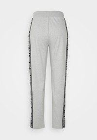 Grijze joggingbroek met een zwarte zijstreep met witte tekst. Elastische tailleband, rechte broekspijp en zachte textuur.