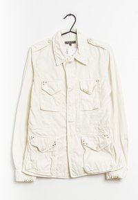 Světlý krémový dlouhý rukáv vojenského stylu kabát s dvěma náprsními kapsami a dvěma dolními kapsami, s patentními knoflíky a dekorativními hroty.