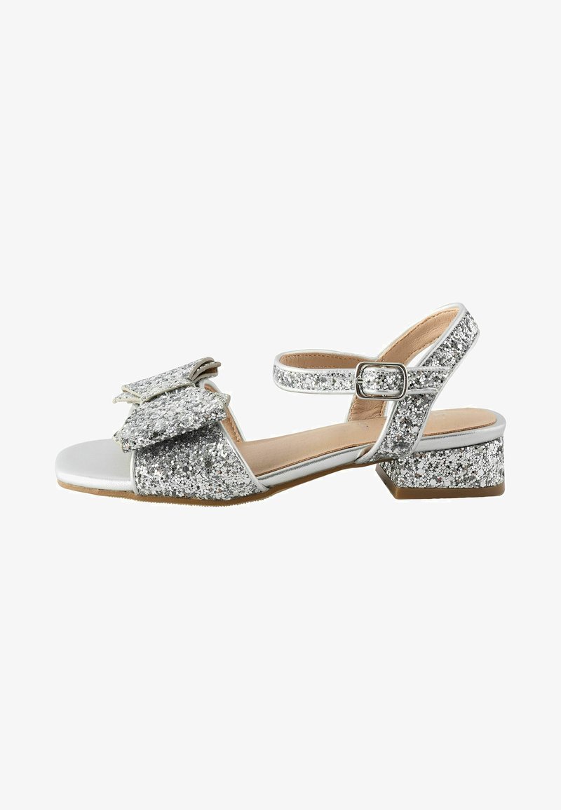 Sandale argentée pailletée à bout ouvert, talon bloc bas, bride cheville avec boucle, et nœud décoratif sur la bride avant.