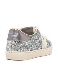 Zapatillas de purpurina plateada con detalles en crema, punta redonda y una lengüeta metálica en el talón con la etiqueta "BROWNIE by victoria." Suela de goma.