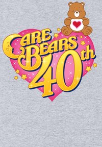 Camisa gris claro con un gráfico de texto colorido: "Care Bears 40th" en amarillo, contorneado en azul marino, con un corazón rosa y un oso marrón sosteniendo un corazón rojo.