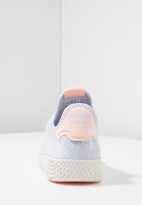Ljusblå mesh-sneakers med en texturerad design, rosa hälaccent och vit gummisula med ett mönstrat grepp.