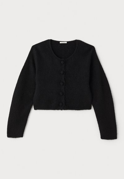 Cardigan corto nero realizzato in materiale morbido e peloso. Presenta un colletto rotondo, maniche lunghe e sei bottoni decorativi lungo la parte anteriore.