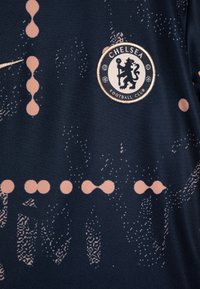 Jersey nogometnega kluba Chelsea v mornarično modri barvi s pink abstraktnimi vzorci. Vsebuje krožno logo in Nike swoosh v kovinskem finišu.