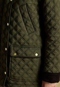 Kurtka w oliwkowym kolorze z pikowaniem w romby, z zamykanym na zamek kieszonką, zatrzaskami oraz mankietami z cordurowego materiału z logo "Joules".
