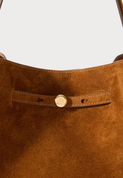 Καφέ σουέτ τσάντα χειρός με επίπεδο λουράκι και χρυσές μεταλλικές λεπτομέρειες και ραφές. Λείος υφασμάτινος χαρακτήρας με γυαλιστερή φινίρισμα.