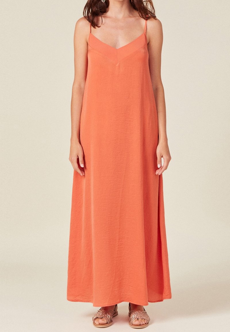 Robe longue corail vif avec bretelles spaghetti ajustables, décolleté en V et tissu léger texturé. Ourlet arrondi à la longueur cheville.