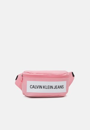 Różowa materiałowa torba na talię z przednim zamkiem błyskawicznym i białą metką z napisem "CALVIN KLEIN JEANS" czarnym tekstem.