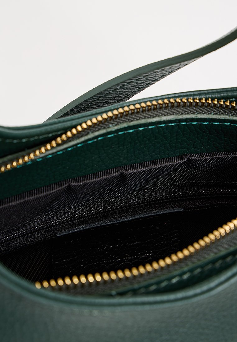 Bolso de cuero verde oscuro con cremallera dorada parcialmente abierta, mostrando el forro interior negro y una correa.