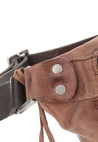 Sac banane en cuir marron avec une surface texturée, des boutons-pression en métal et une sangle marron. Caractéristiques d'un design élégant et compact pour un transport facile.