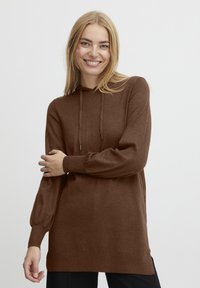 Pull en tricot brun avec capuche, manches longues, poignets côtelés et coupe décontractée. Texture douce et fentes sur les côtés à l'ourlet.