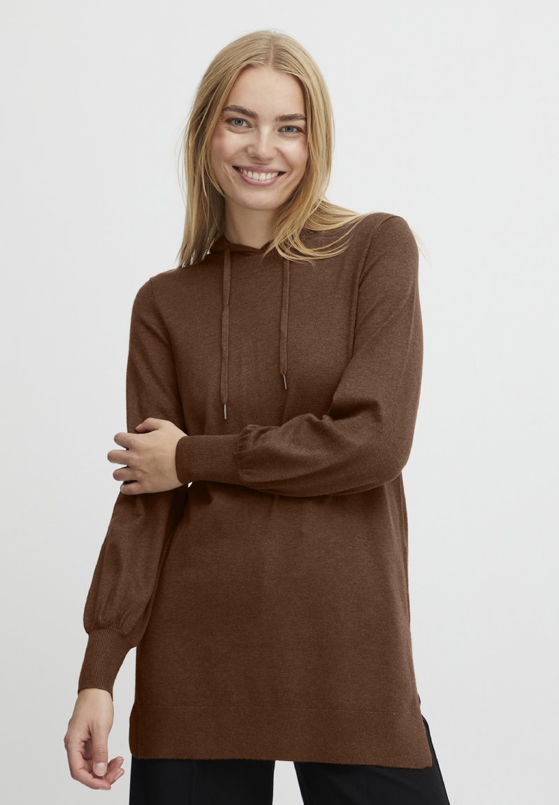 Pull en tricot brun avec capuche, manches longues, poignets côtelés et coupe décontractée. Texture douce et fentes sur les côtés à l'ourlet.