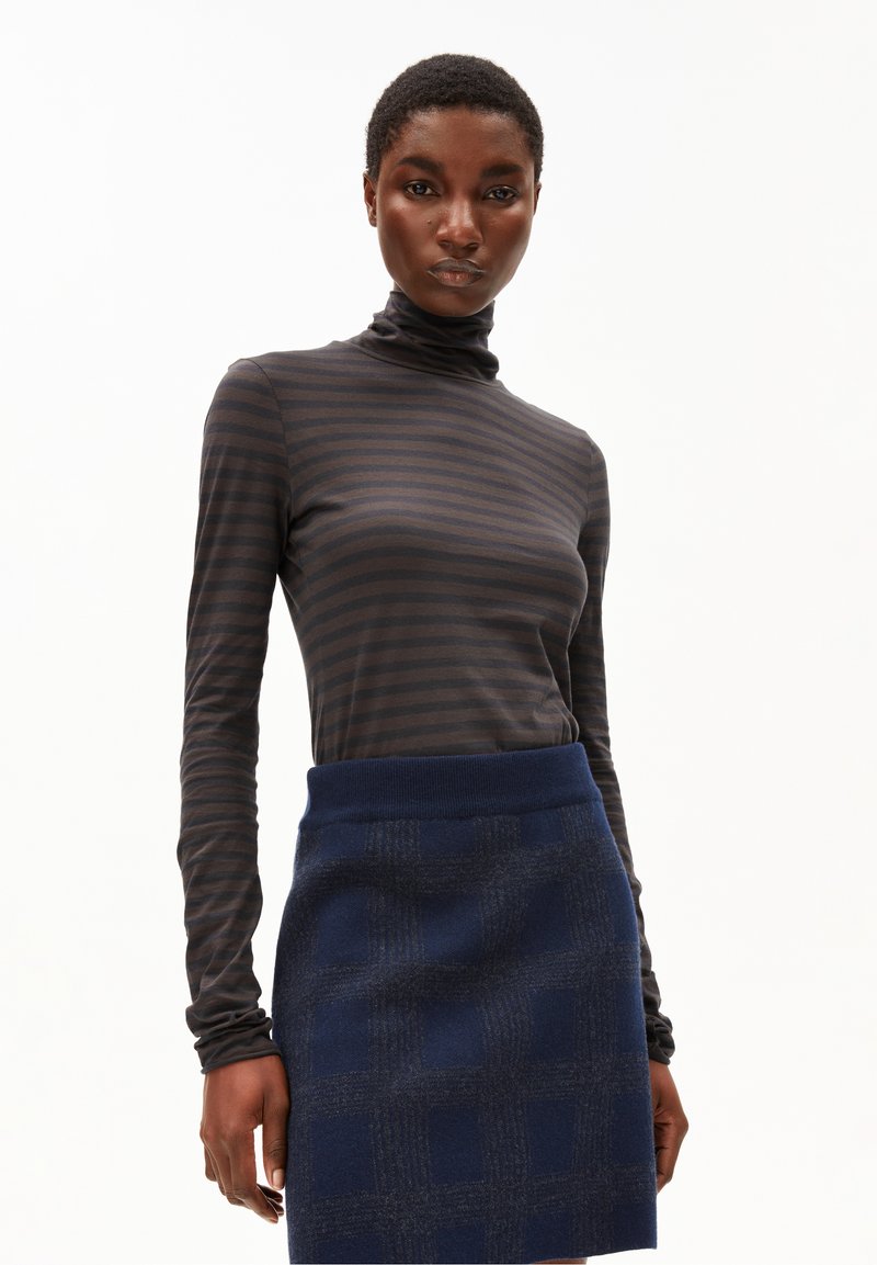 Langärmliger, dunkelgrau gestreifter Rollkragenpullover kombiniert mit einem marineblauen gemusterten Rock mit geripptem Bund und geometrischem Design.