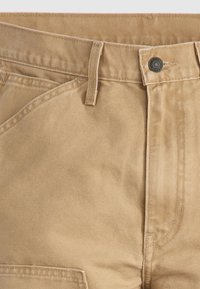 Μπεζ βαμβακερό παντελόνι με κλασικό σχεδιασμό, επίπεδη μπροστινή όψη, θηλιές για ζώνη και μεταλλικό κούμπωμα κουμπιού. Λείο ύφασμα με διακριτικές ραφές.