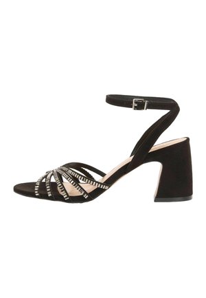 Čierna semišová sandála na podpätku s remienkom okolo členka, hrubým podpätkom a viacerými prednými remienkami zdobenými malými obdĺžnikovými striebornými cvokmi.
