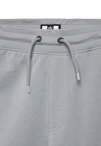 Lysegrå joggebukser med elastisk midje, justerbar snor og sidelommer. Myk stoff med glatt tekstur og sømdetaljer.