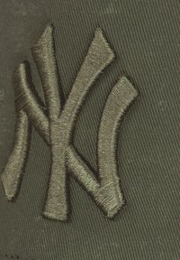 Green cap featuring an embroidered dark green New York Yankees logo. The material is textured with a subtle pattern.