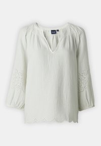 Lichtgroene blouse met V-hals, geplooide details, driekwartmouwen, gegolfde zoom en eyelet borduurwerk op de mouwen.