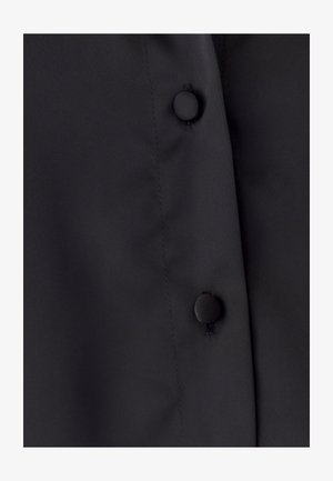 Czarna tkanina o gładkiej fakturze posiada zapięcie na guziki wzdłuż krawędzi, minimalne detale szycia oraz czysty, nowoczesny design.