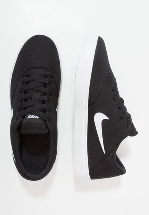 Baskets Nike noires avec logo swoosh blanc, semelles blanches et lacets noirs, vues de dessus et de côté sur un fond blanc.