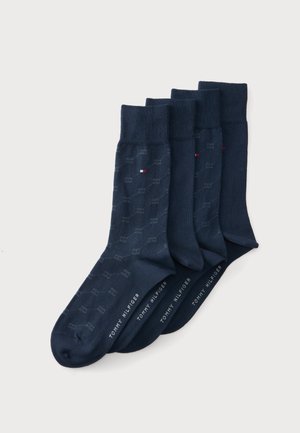 Τέσσερα ζευγάρια σκούρες μπλε κάλτσες Tommy Hilfiger με διακριτικά γεωμετρικά σχέδια και μικρές λεπτομέρειες με το λογότυπο σε κόκκινο, άσπρο και μπλε.
