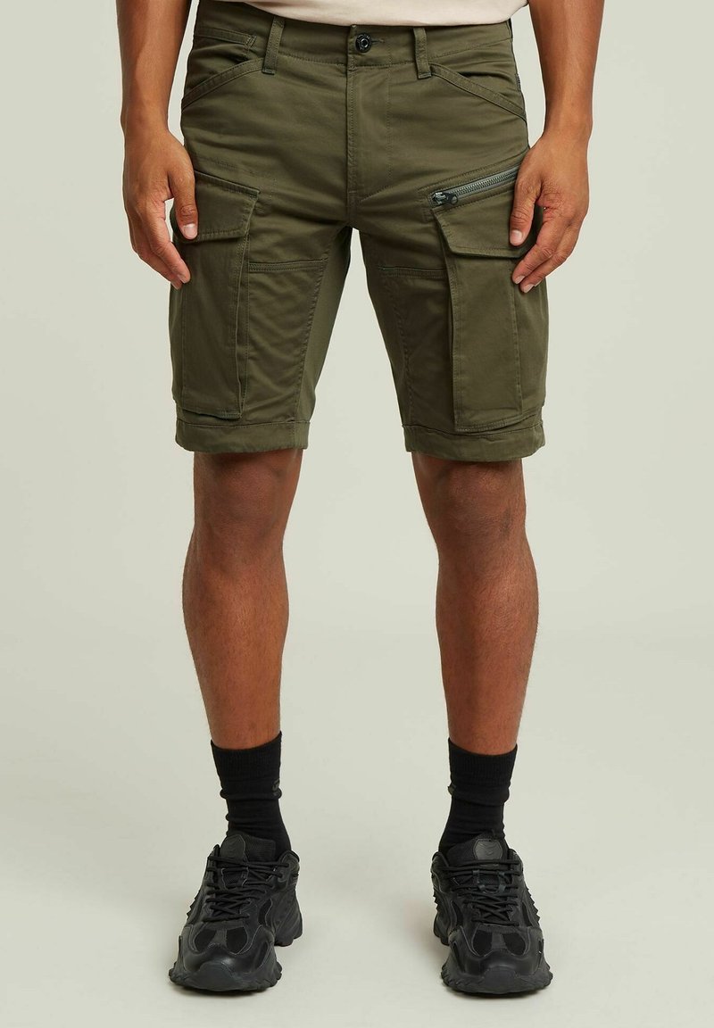 Pantaloni cargo verde oliva con molte tasche, dettagli con zip e risvolti. Realizzati in tessuto resistente, caratterizzati da una chiusura con bottone.