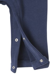 Nahaufnahme eines marineblauen Hosenbeins aus Stoff mit drei silbernen Druckknöpfen, die teilweise entlang der Innennähte geöffnet sind.