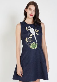 Vestido azul marino con bordado de flores y pájaros, con tejido texturizado, diseño sin mangas y falda acampanada.