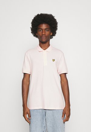 Polo shirt rosa chiaro in cotone, con colletto a tre bottoni e un piccolo logo a forma di farfalla gialla sul lato sinistro del petto.