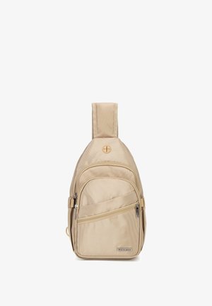 Sac à dos beige à une seule bretelle avec plusieurs compartiments zippés et un petit port rond pour écouteurs près du haut.