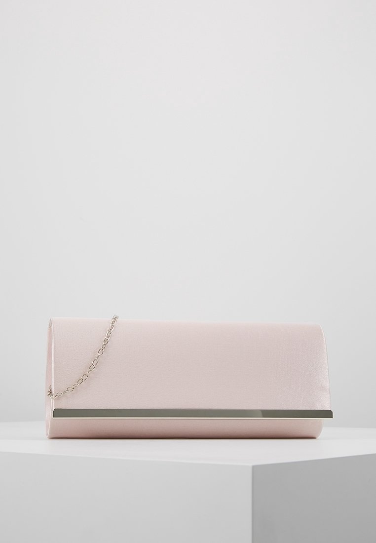 Pochette rectangulaire rose clair avec une chaîne argentée et un détail métallique argenté sur le devant, placée sur une surface blanche.