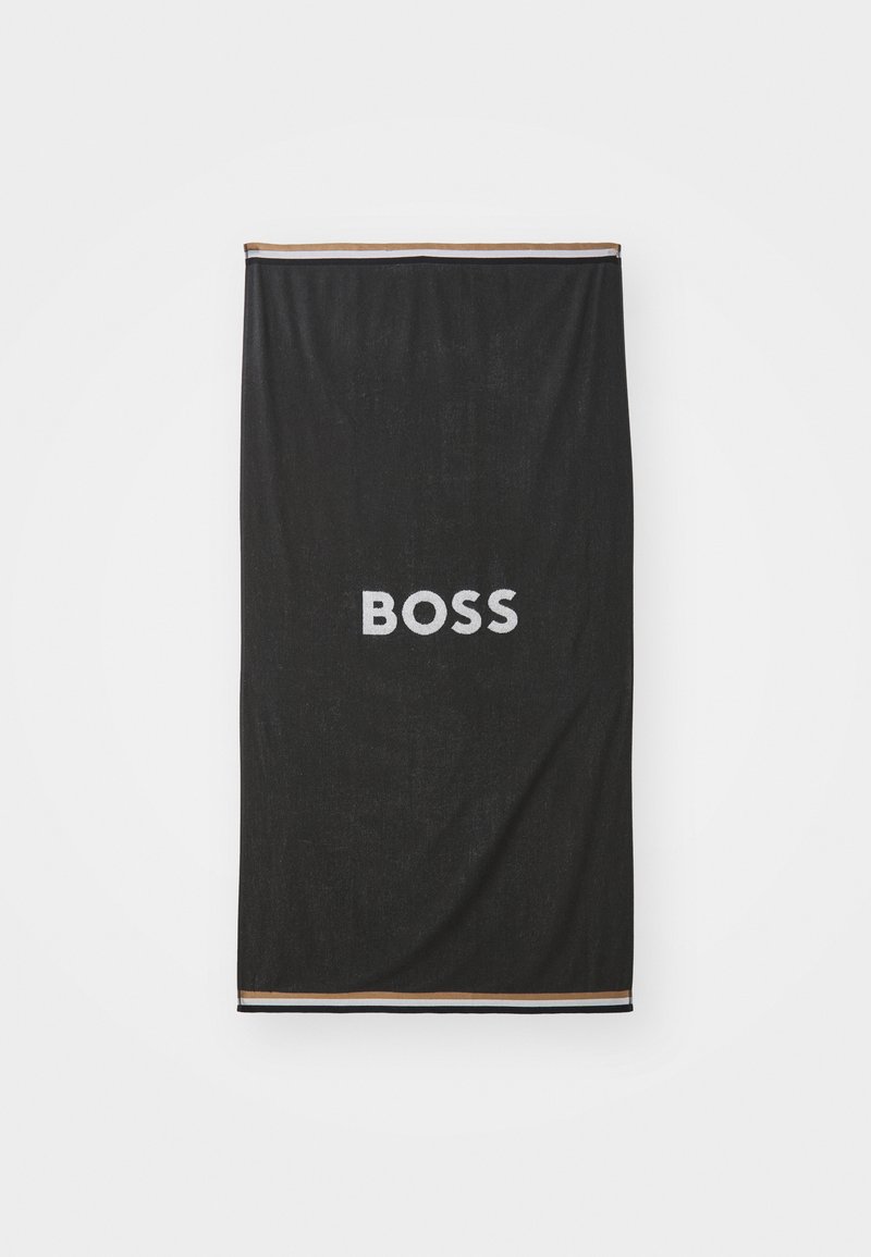 Svart håndkle med en myk tekstur som har ordet "BOSS" i fete hvite bokstaver, omkranset av en stripete rand i svart, hvitt og brunt.