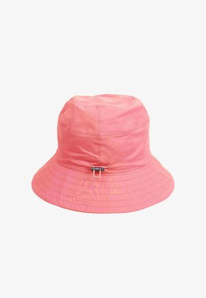Koralowy różowy kapelusz typu bucket z szerokim rondem, widocznym przeszyciem oraz małym czarno-srebrnym zapięciem z przodu na środku.