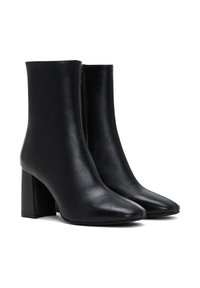 Botas de cuero negro hasta el tobillo con punta afilada, tacón bloque alto y un acabado suave. Cuenta con una cremallera lateral para facilitar su uso.