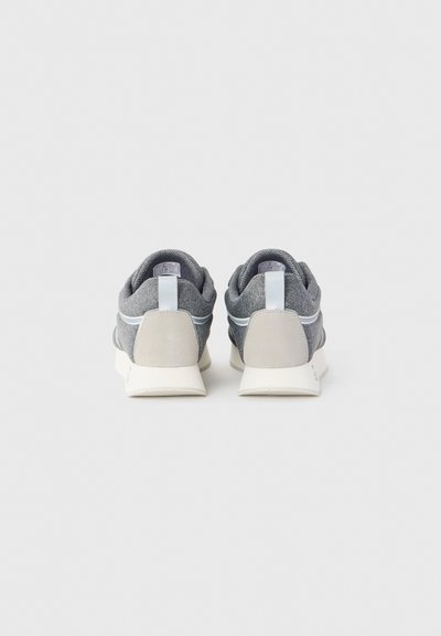 Pair of gray sneakers with white soles and heel pulls, shown from the back on a plain light gray background.