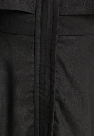 Must mustri, millel on sile tekstuur ja nähtavad õmblused ning sirge õmblus. Üldine disain on lihtne ja ilma kaunistusteta.