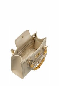 Beige leren handtas met een gestructureerd ontwerp, gouden hardware en een bamboe hengsel. Het interieur heeft een stoffen voering en sleufzakken.